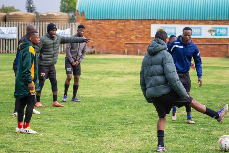 A coach demonstrates technique to players