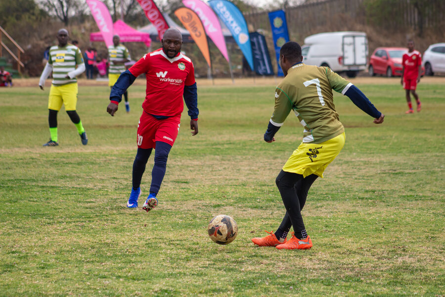 Players chase the ball along the sideline flags